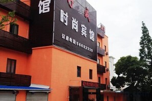 Een hotel met een opvallend bord, meerdere ramen en een duidelijke ingang.