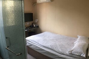 A room with a bed, a desk with a computer, and a television. - Ziwei Shishang Hotel (Shanghai)