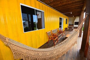 Relax in a cozy outdoor space with a hammock, dining table, and brick oven.