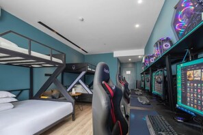A room with bunk beds, a desk with a computer, and multiple gaming monitors. - Rest Comfort Hotel (Wenzhou Oubei Shuangta Road) (Yongjia)