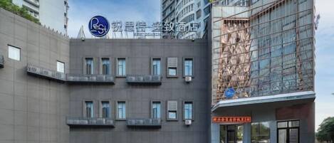 Un edificio moderno con fachada plana, múltiples ventanas y un letrero que indica un espacio de negocios u oficina.