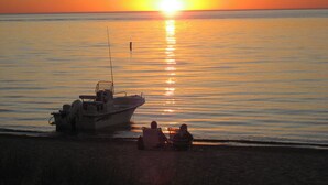 A boat on a calm body of water during sunset. - Classic mid-century Long Beach home with modern updates - Walk to Stop 30 beach! (Long Beach)