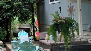 A deck with outdoor furniture, including chairs and a sofa, and a hanging plant. - Classic mid-century Long Beach home with modern updates - Walk to Stop 30 beach! (Long Beach)
