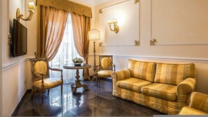 A room with a sofa, two chairs, a table, and a TV. - Alta Luxury Apartments - Oca Apartment (Rome)