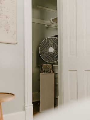 Een witte kast met een ventilator, een kaart en een koffer.