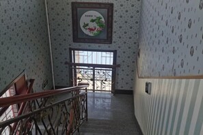Una escalera con barandilla, una puerta al final e interesante papel tapiz.