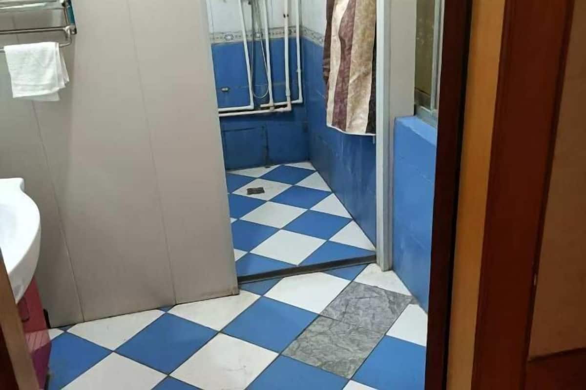 Une salle de bain avec un carrelage à motifs géométriques, un lavabo et un porte-serviettes.