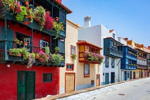 A row of colorful buildings with balconies adorned with potted plants and flowers. - Home Elias LA Palma City (Santa Cruz de la Palma)