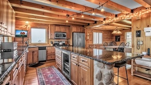 Una cocina amplia con armarios de madera, encimeras de granito y una isla grande.