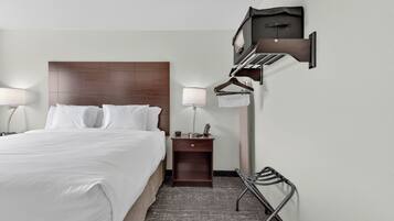 A hotel room with a bed, bedside lamps, a nightstand, a wall-mounted TV, and a coat rack.