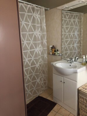 Chuveiro, toalhas de banho, papel higiênico