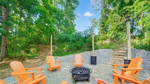 Un espace extérieur aménagé avec des fauteuils Adirondack et un foyer.