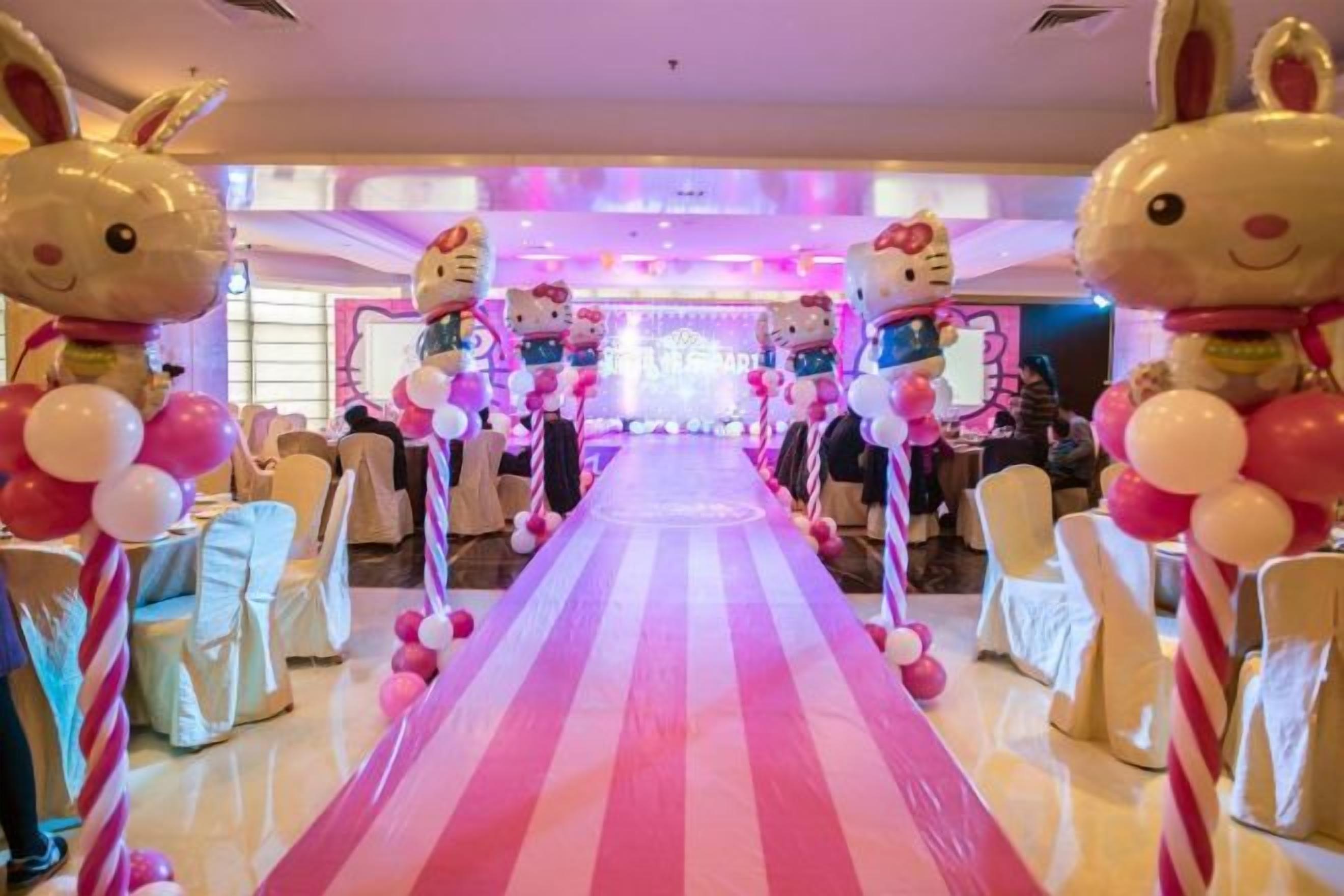 A venue with a central aisle, round tables, and chairs arranged for an event.