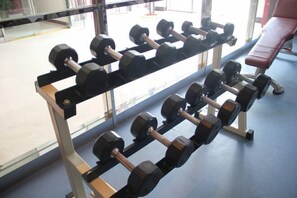 A row of dumbbells on a rack in a gym with a bench in the background. - Xi'an Zhongxing Hetai Hotel (Xi'an)