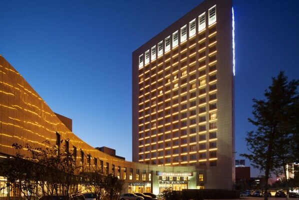A multi-story hotel with a modern facade, illuminated windows, and a prominent entrance. - Xi'an Zhongxing Hetai Hotel (Xi'an)