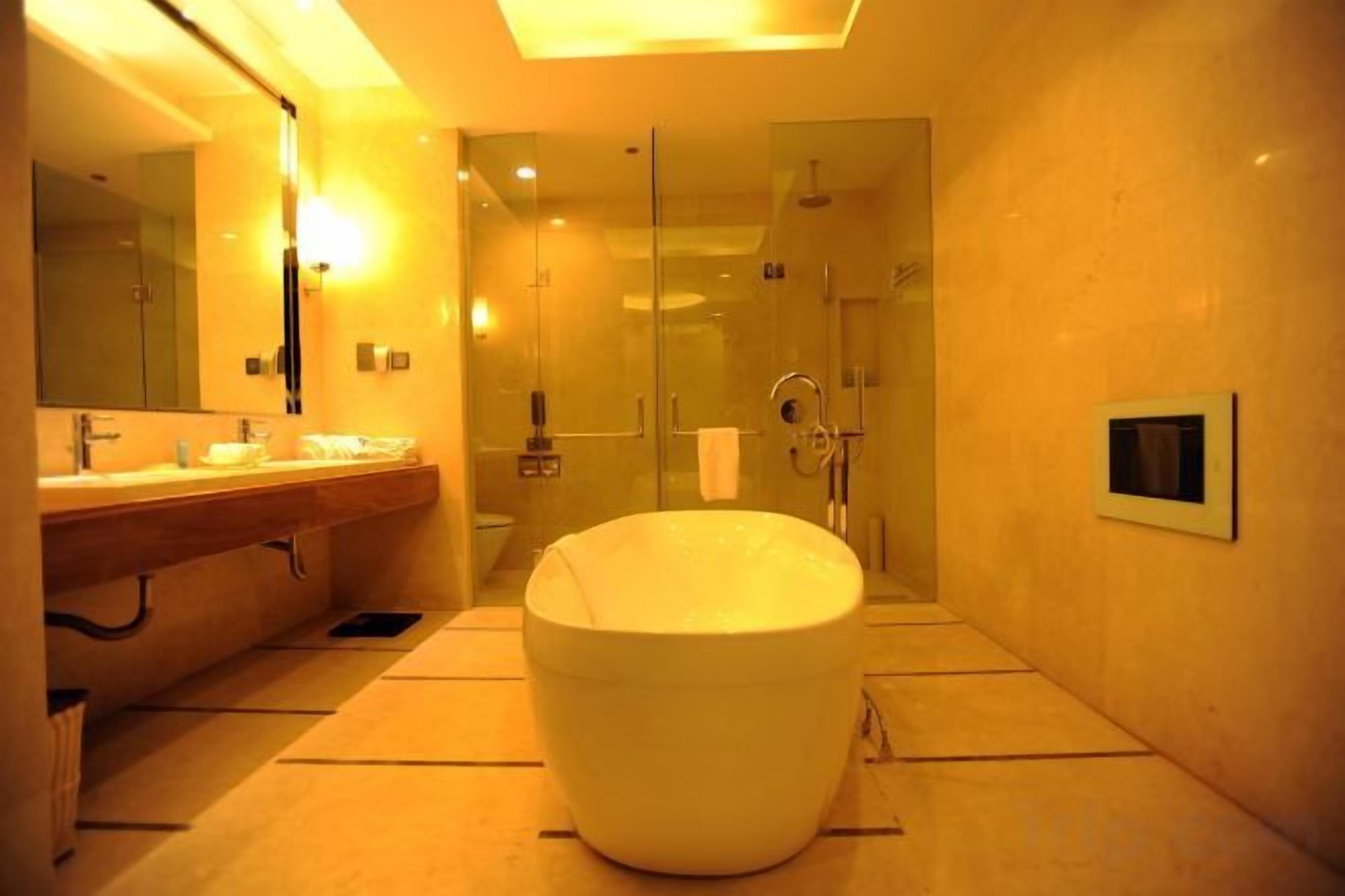 A modern bathroom with a large bathtub, a glass shower enclosure, and a vanity with dual sinks.