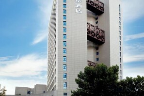 Un edificio de hotel alto con varios pisos y balcones.
