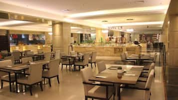 A spacious restaurant with multiple tables and chairs, a bar area, and a marble counter.