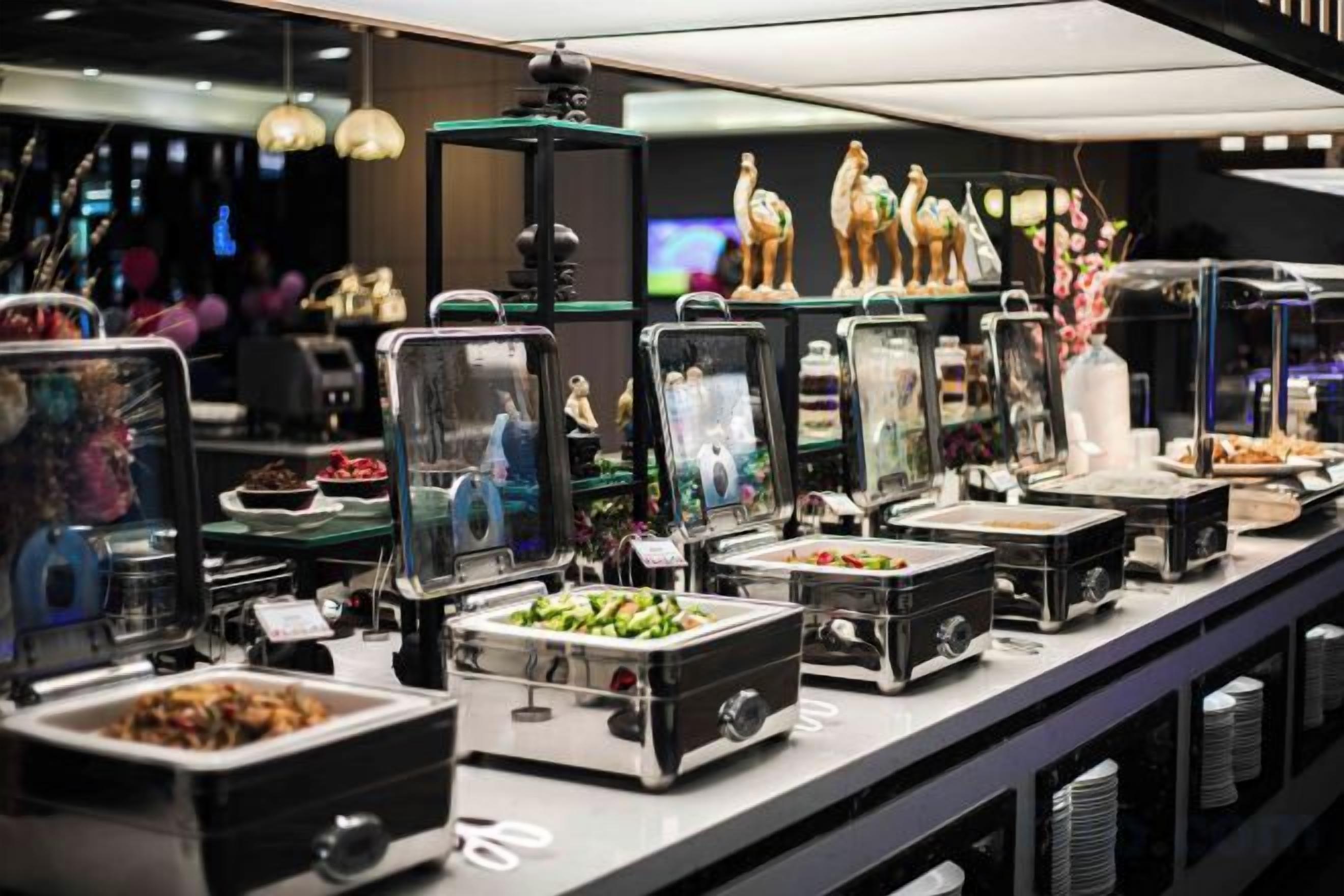 A buffet setup with various food containers and decorative items.