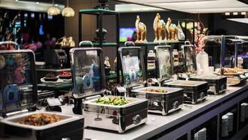 A buffet setup with various food containers and decorative items.