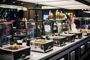 A buffet setup with various food containers and decorative items. - Xi'an Zhongxing Hetai Hotel (Xi'an)