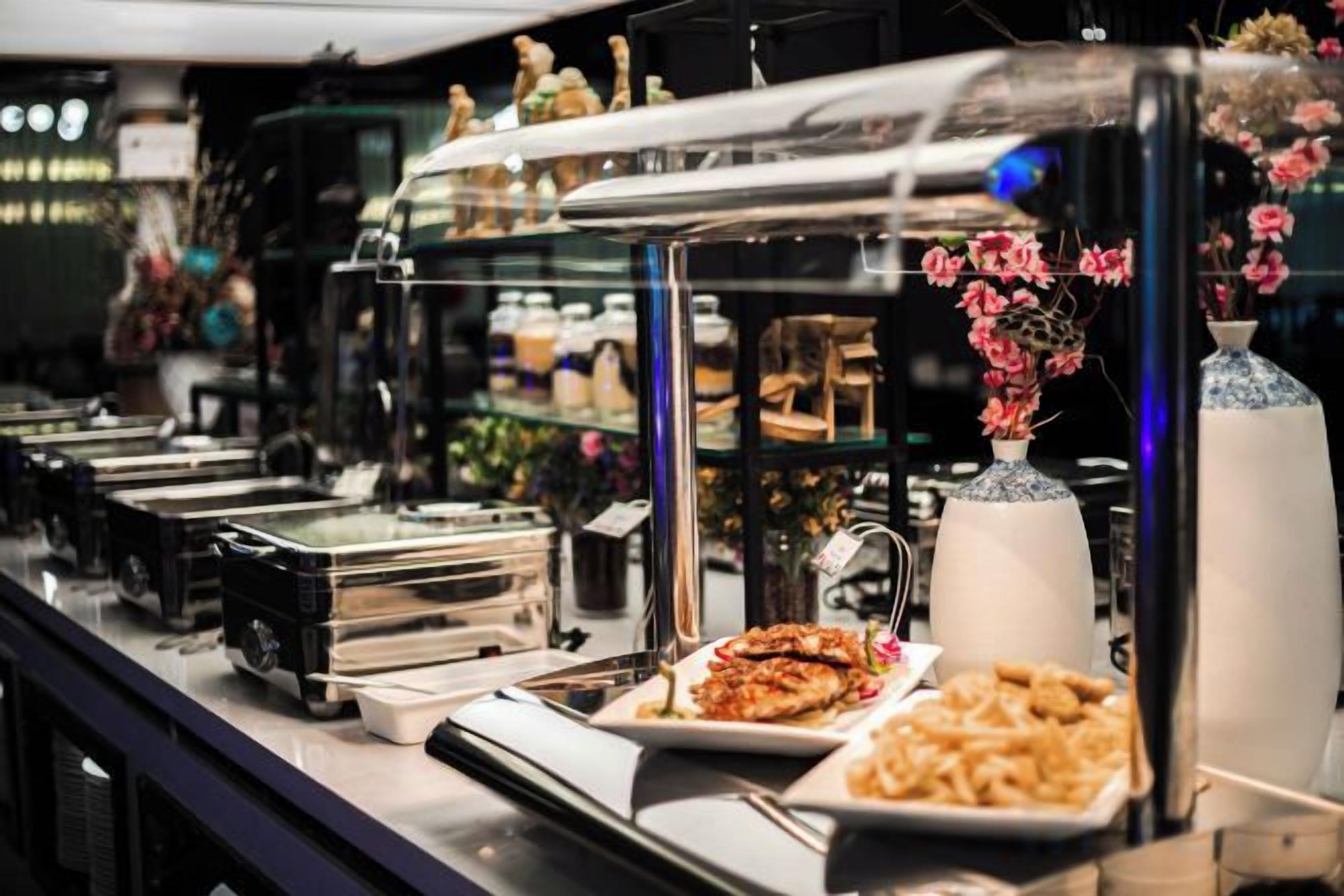 Een buffetgedeelte met diverse gerechten en een glazen vitrine.