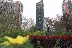 Un edificio alto con un cartel que indica el camino hacia un parque empresarial.