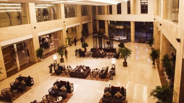 A spacious lobby with multiple seating areas, a central fountain, and a high ceiling with reflective surfaces. - Xi'an Zhongxing Hetai Hotel (Xi'an)