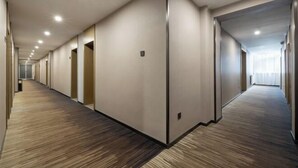 A long, narrow hotel corridor with wooden flooring, recessed ceiling lights, and doors leading to rooms. - GreenTree Inn (Affiliated Hospital of University of Traditional Chinese Medicine) (Taiyuan)