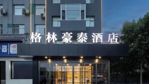 A hotel entrance with glass doors and a sign in Chinese characters. - GreenTree Inn (Affiliated Hospital of University of Traditional Chinese Medicine) (Taiyuan)