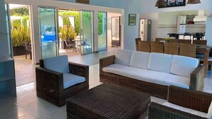 A spacious living area with wicker furniture, a white sofa, and a dining area with wicker chairs. - Whole house: villa in Llano Del Pozo, Colombia (Llano Del Pozo)