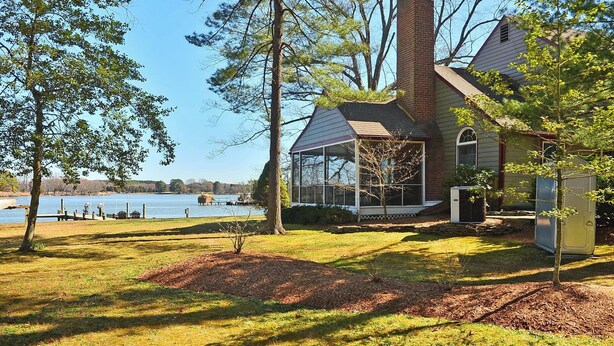 A house with a large glass conservatory, a fenced yard, and a lake view. - A Waterfront Retreat with pier and pool.  Spacious 4 bedrooms near Chestertown. (Chestertown)
