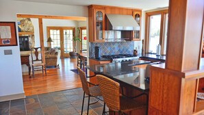 A spacious kitchen with wooden cabinets, a large island, and a stone backsplash. - A Waterfront Retreat with pier and pool.  Spacious 4 bedrooms near Chestertown. (Chestertown)