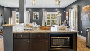 A modern kitchen with dark cabinetry, granite countertops, and a built-in microwave. - Forest Mountain Views with Yard, 3-bedroom pet friendly home Fairview (Fairview)