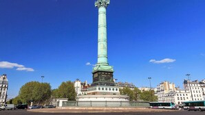A tall, green monument with a statue on top, surrounded by trees and buildings. - Refined Apartment with Jacuzzi and AC - 6P PARIS 10 minutes République Bastille (Paris)