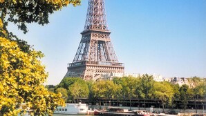 The Eiffel Tower with a view of the Seine River and boats in the foreground. - Refined Apartment with Jacuzzi and AC - 6P PARIS 10 minutes République Bastille (Paris)