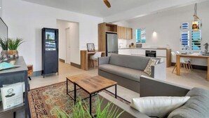 Un salon moderne avec un canapé, une table basse et un ventilateur de plafond.