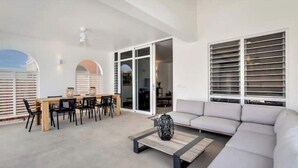 Un salon moderne comprenant un canapé, une table basse et un coin repas avec des chaises et une table.