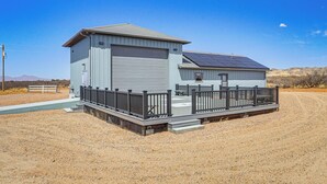Ein eingeschossiges Gebäude mit Garage und überdachter Veranda.