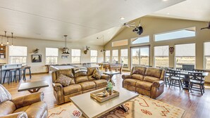 A spacious living area with leather sofas, a coffee table, and a dining area with a large window. - Riverside Retreat in Bridgeport w/ Game Room! (Bridgeport)