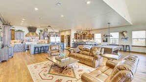 A spacious living area with a large leather sofa, a coffee table, and a kitchen in the background. - Riverside Retreat in Bridgeport w/ Game Room! (Bridgeport)