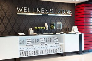 Uma mesa de recepção com uma placa que diz 'WELLNESS ZONE'.