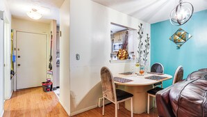 A dining area with a round table, chairs, and a brown leather couch. - 3 Mi to Dtwn New Haven: Colorful Condo w/ Yard! (East Haven)