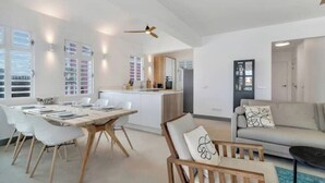 A modern living room with a dining area, a sofa, and a ceiling fan. - Waterdream Villa, Water Villas (Kralendijk)