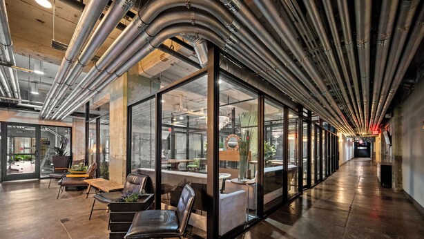 A modern interior with glass partitions, leather seating, and exposed ductwork. - Downtown Dallas Loft (Dallas)