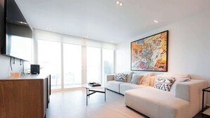 Una sala de estar moderna con un sofá, una mesa de centro y un cuadro en la pared.