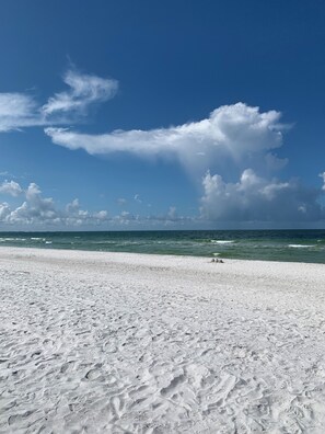 Ein Strand mit weißem Sand und blauem Himmel.