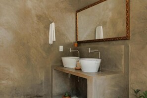 Bathroom features a large mirror, two sinks, and a wooden countertop.