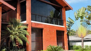 A modern two-story building with a brick facade, large windows, and a balcony. - Rede Andrade Rio Branco (Rio Branco)
