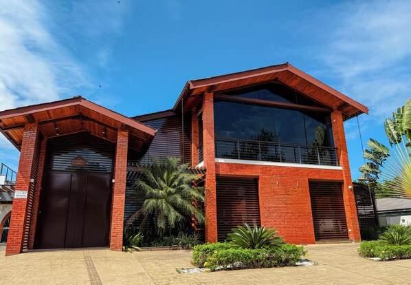 A modern two-story building with a large glass window and a brick facade.